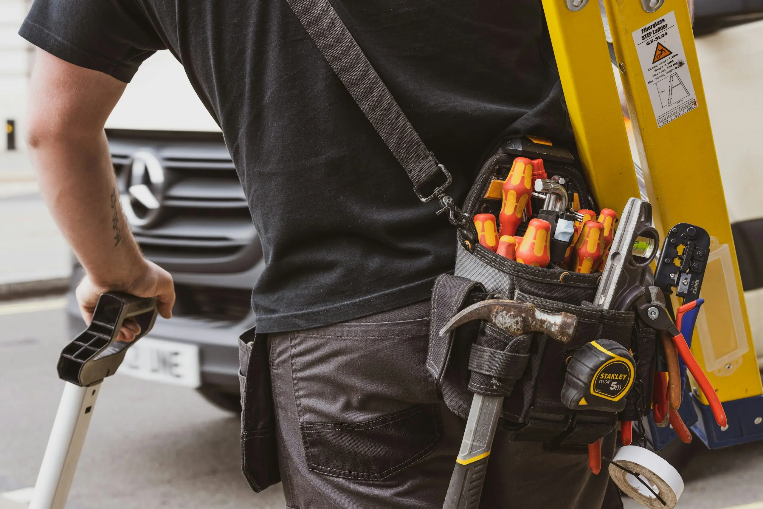 Handwerker mit Werkzeuggürtel bei der Arbeit